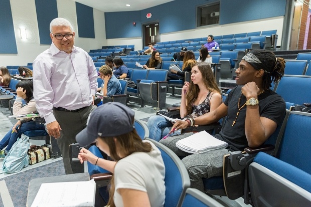 Robert Ruiz works with members of the debate team.